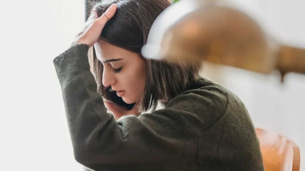 Nachdenklich wirkende Person am Smartphone als Symbolbild für beginnendes problematisches Spielverhalten